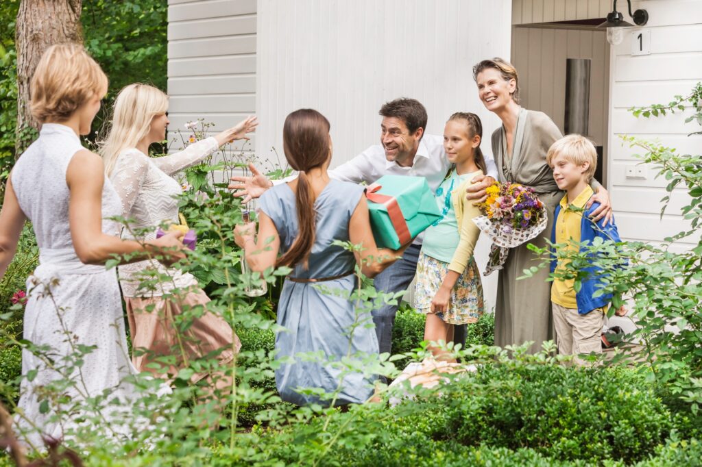 Mature couple greeting family with birthday gifts in garden