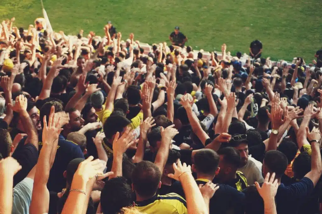 Supporters d'un club sportif levant les bras dans un stade, illustration goodie connecté pour club sportif